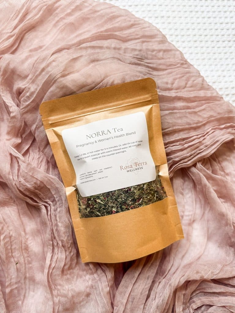 A pouch of NORRA Tea on pink linen